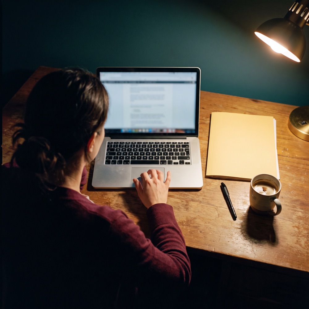 Mulher diante do notebook de madrugada, sem enviar a proposta